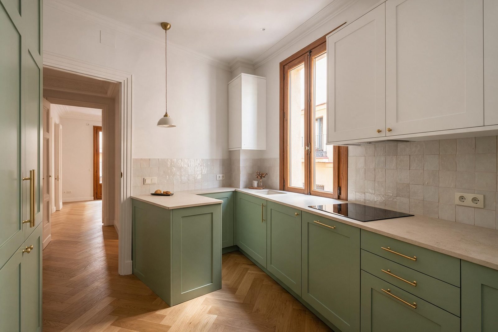Cocina de una reforma integral en Madrid con muebles verde salvia, encimera de piedra y azulejo zellige