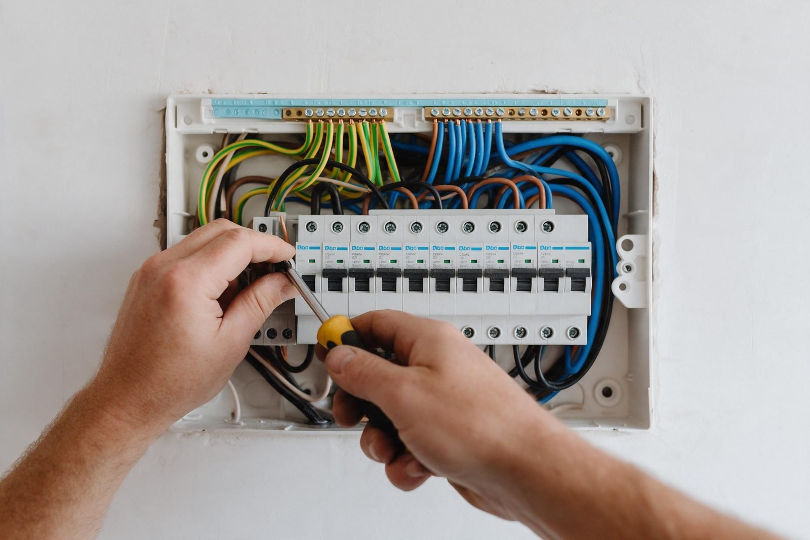 Electricista cableando un cuadro eléctrico nuevo en una vivienda reformada