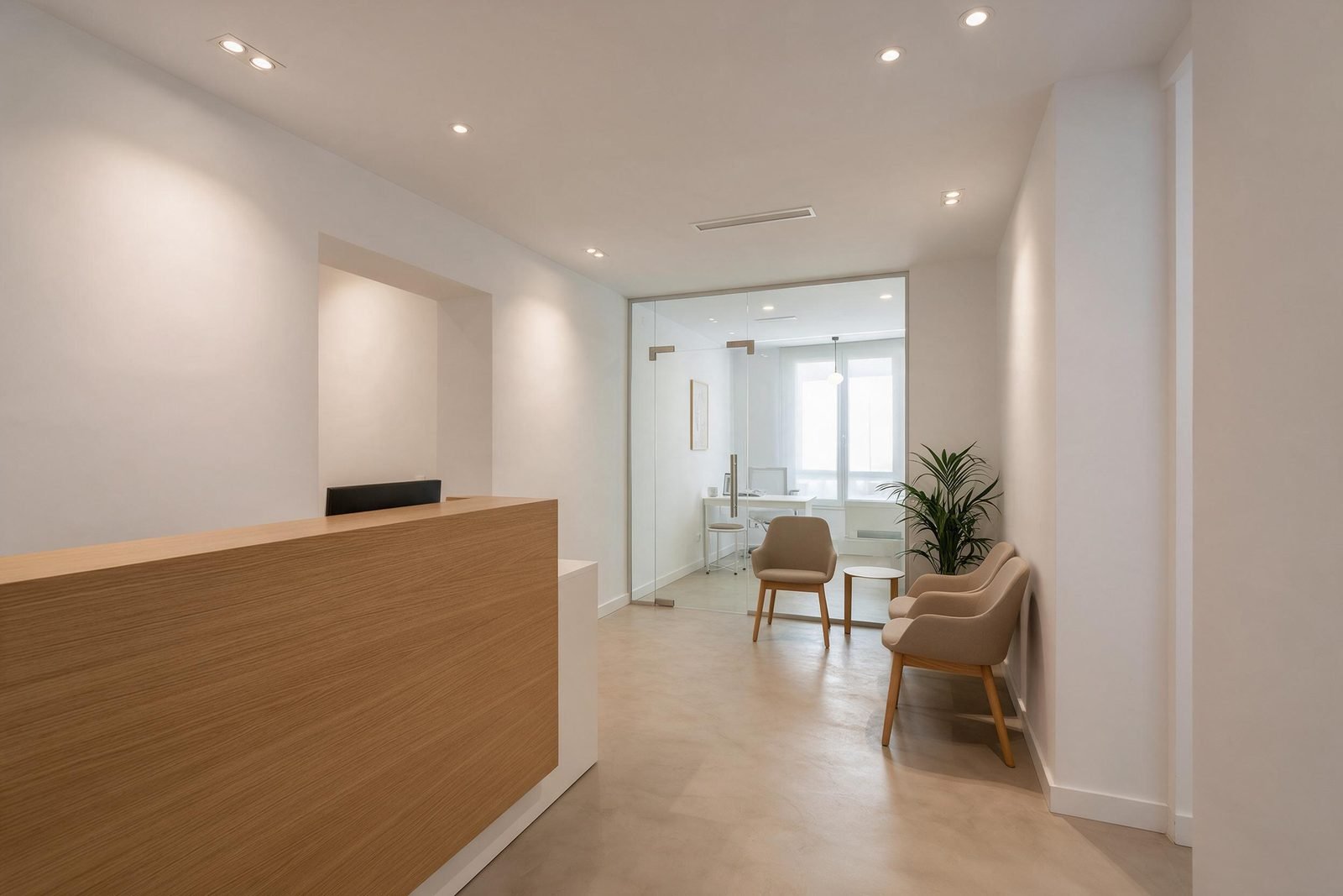 Recepción de una clínica reformada en Madrid con mostrador de madera y mampara de cristal